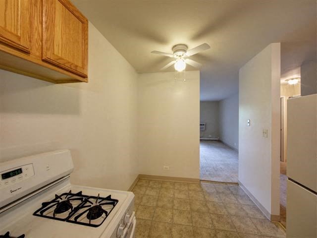 a kitchen with a stove and a ceiling fan