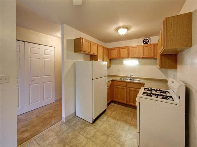 a kitchen with a white refrigerator and a sink