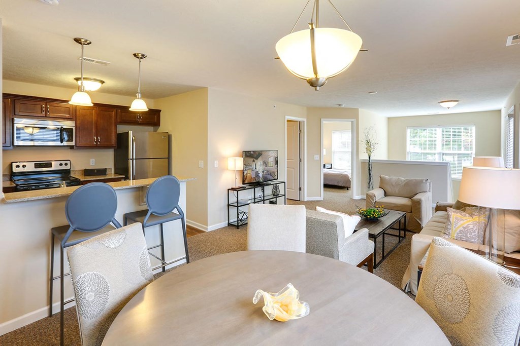 a living room and dining room with a table and chairs