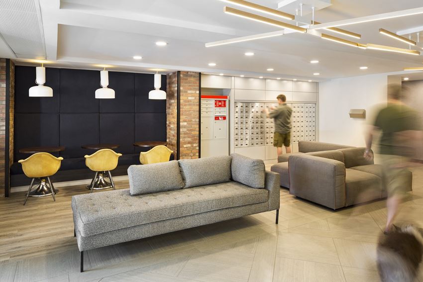 Lobby with a couch and several seating areas, and a person walking through - Photo Gallery 1