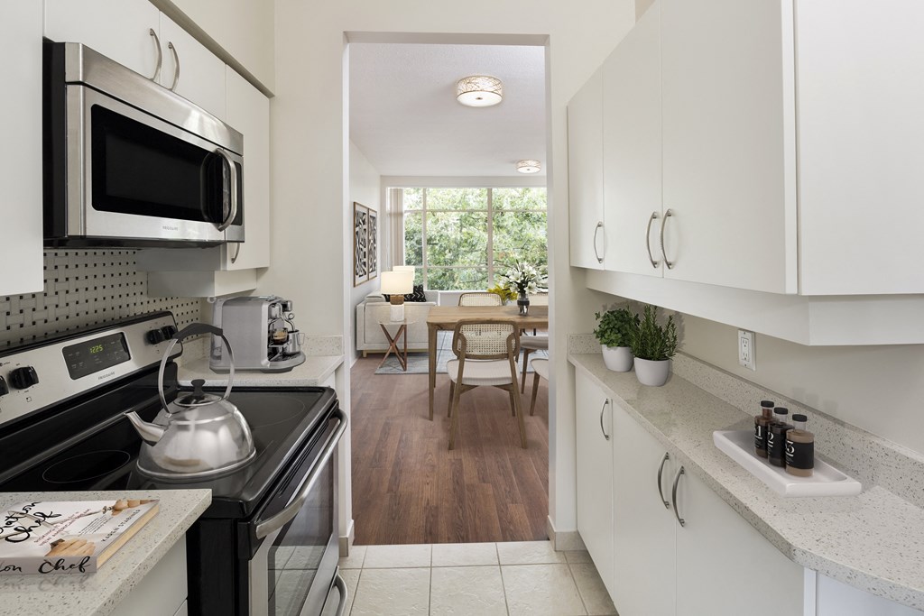 a kitchen with white cabinets and a stove and a microwave