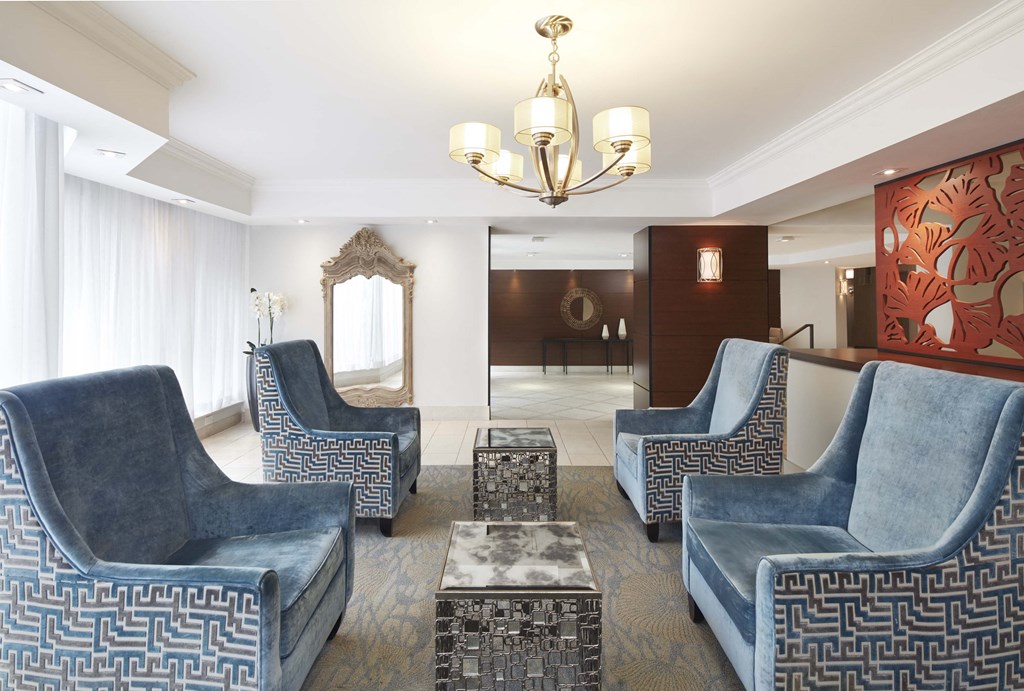 a living room with blue chairs and a chandelier
