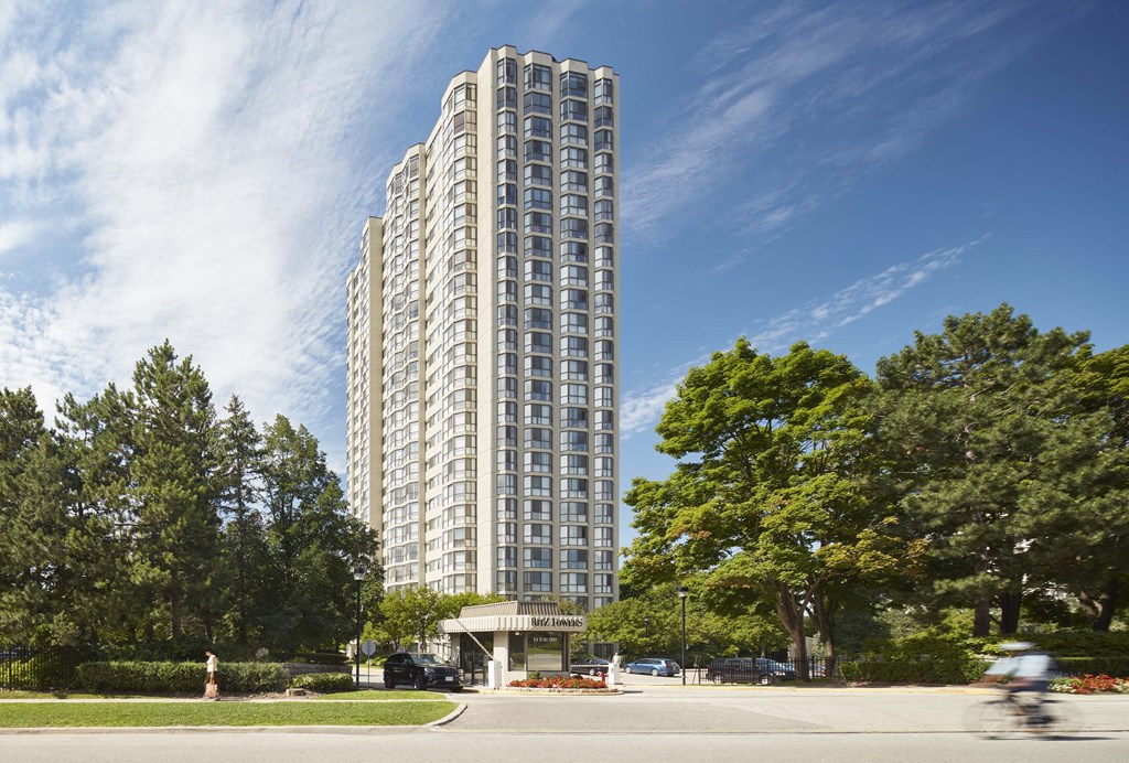 a man riding a bike down a street in front of a tall building