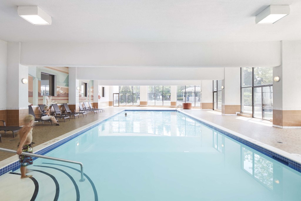 a swimming pool in a hotel with a small child in front of it