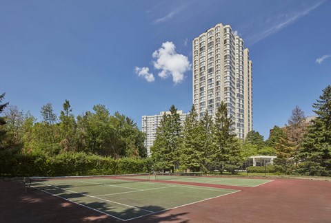 a tennis court in front of a tall building