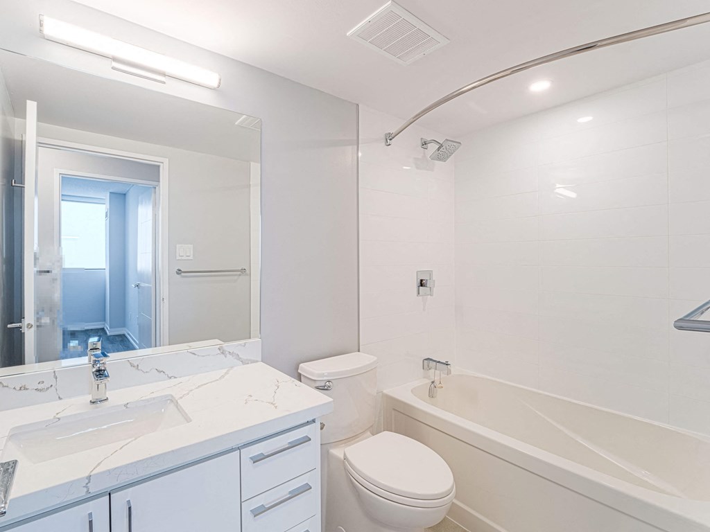 a white bathroom with a tub and a toilet and a sink