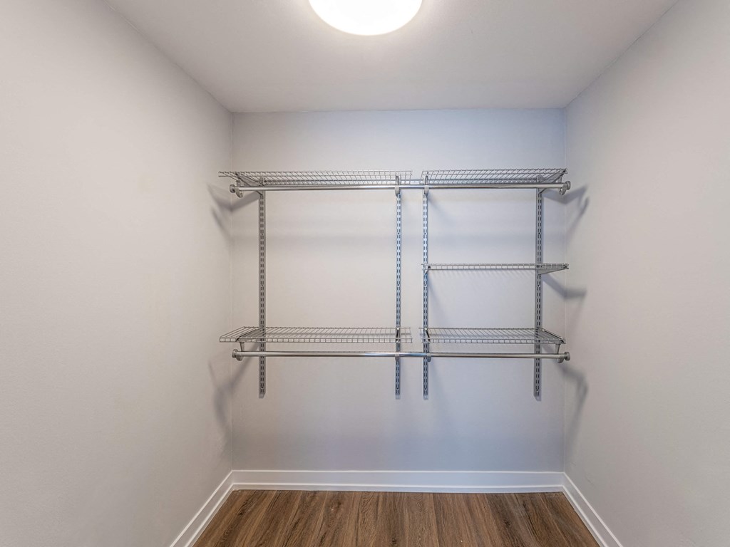 the closet in a renovated apartment with metal shelves and a white wall