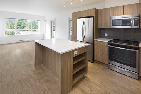 a kitchen with a white counter top and a stainless steel refrigerator