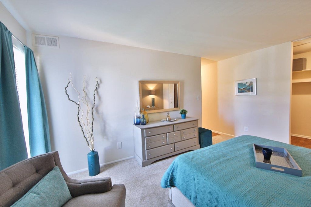 a bedroom with a bed and a dresser with a mirror