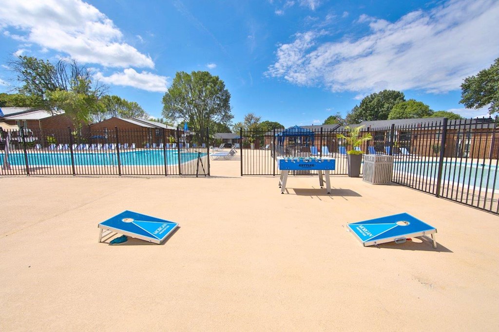 a swimming pool with two benches in front of a fence