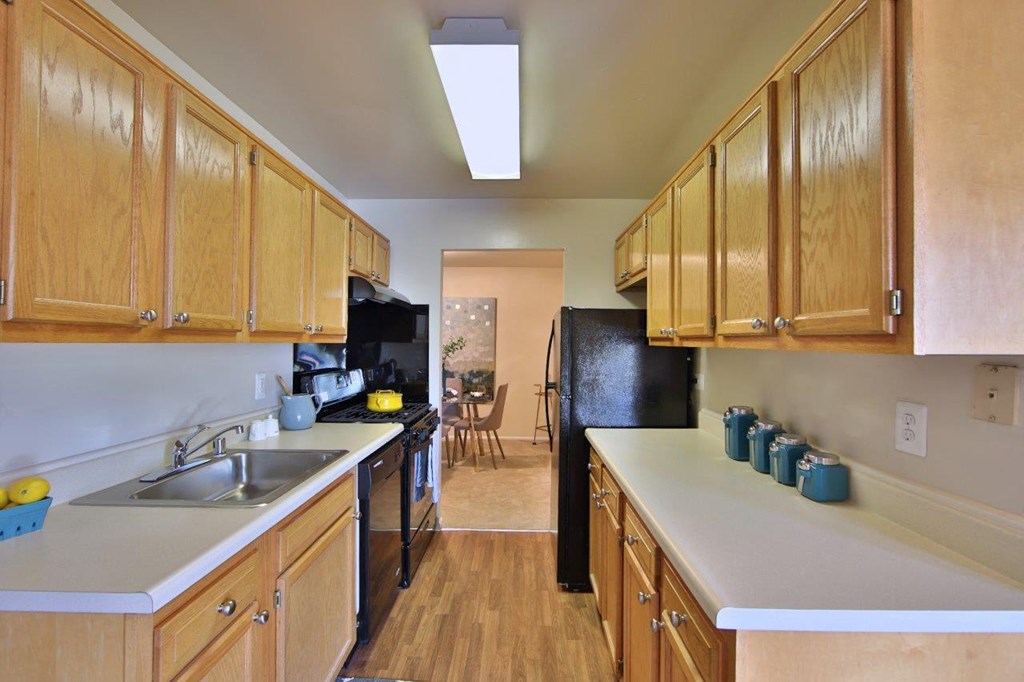 a kitchen with wooden cabinets and a black refrigerator