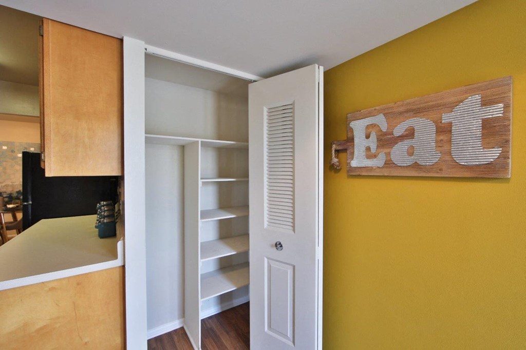 a kitchen with a yellow wall and an open door