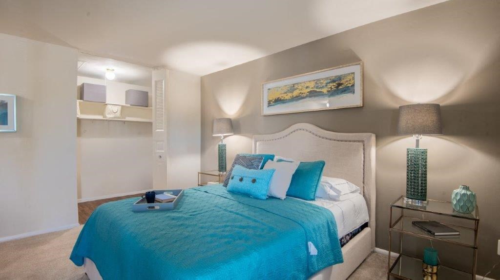 a bedroom with a bed with blue pillows on it