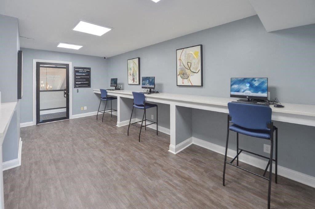a break room with three chairs and a computer on a table