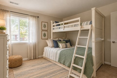 A bedroom with a bunk bed and a window with curtains.