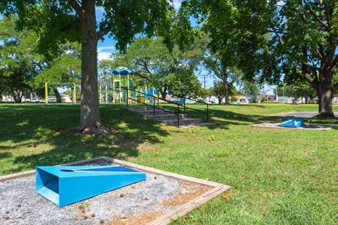 a park with a playground and a trampoline in the grass