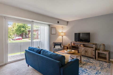 a living room with a blue couch and a television