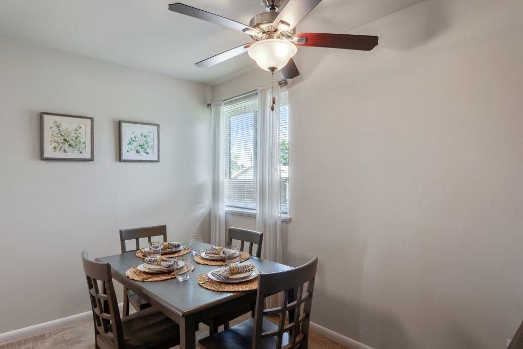 a dining room with a table and chairs and a ceiling fan