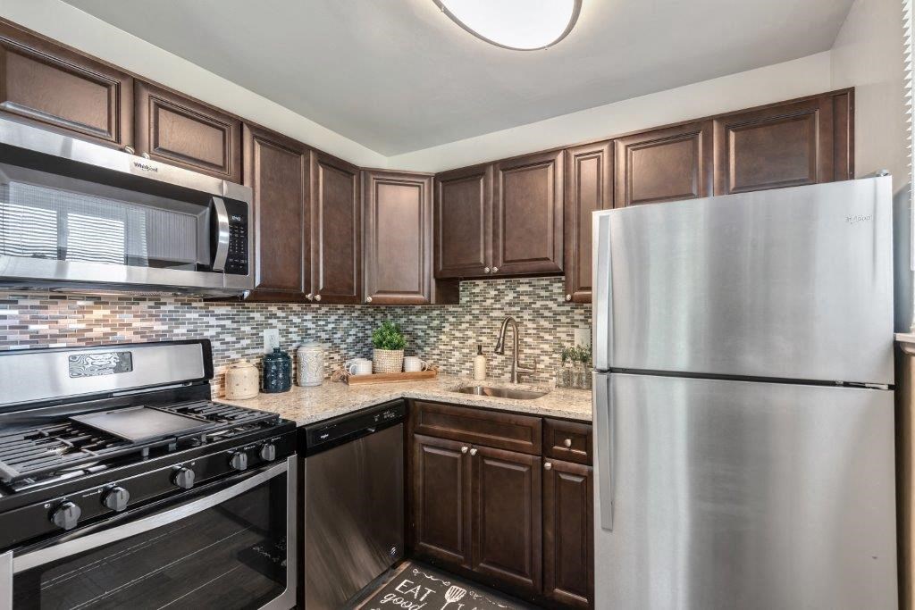 a kitchen with stainless steel appliances and wooden cabinets
