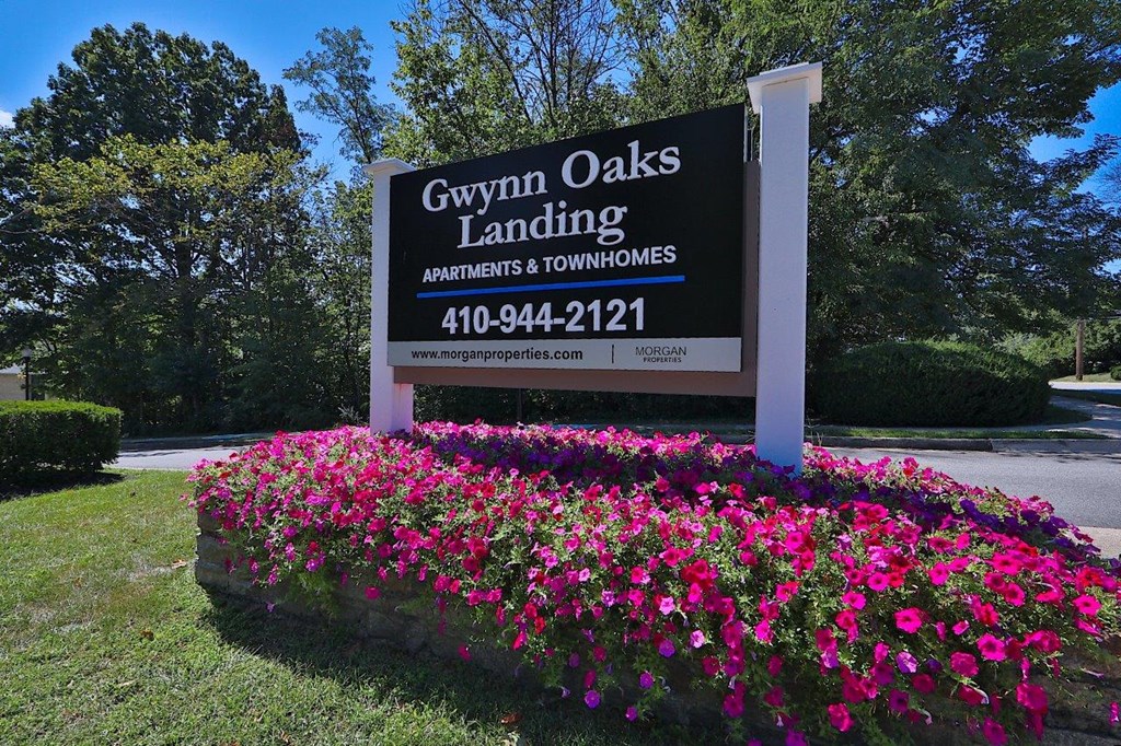 a sign landing apartments and townhomes with flowers
