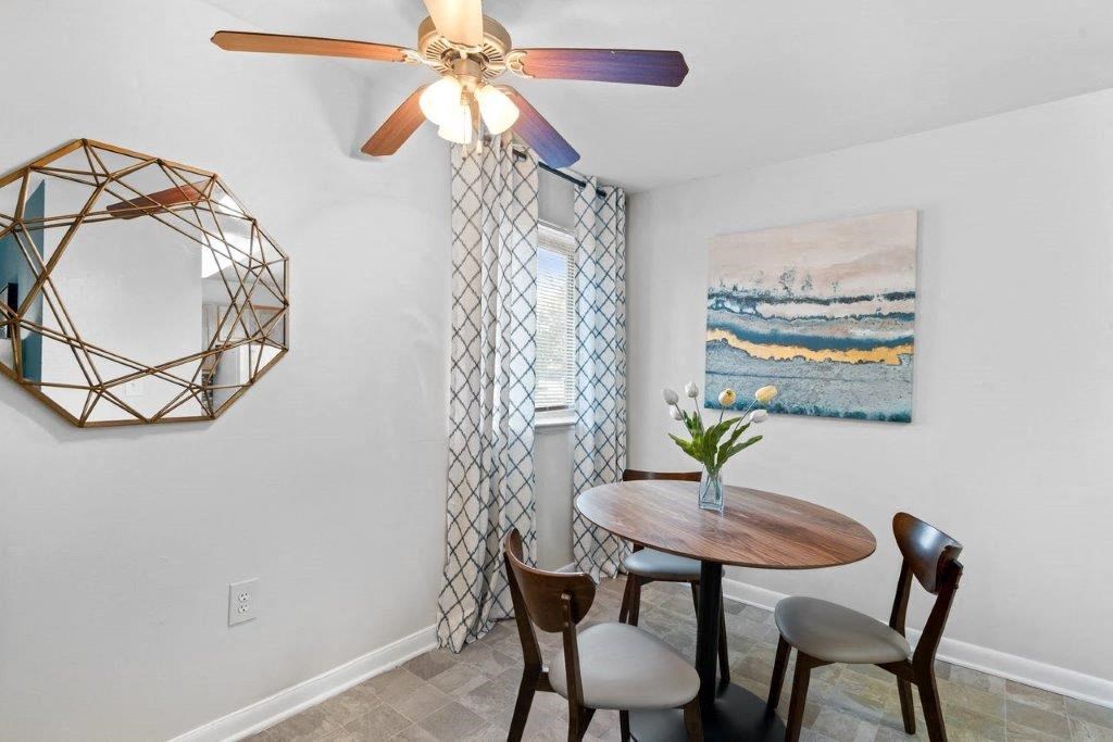 a dining room with a table and chairs and a ceiling fan