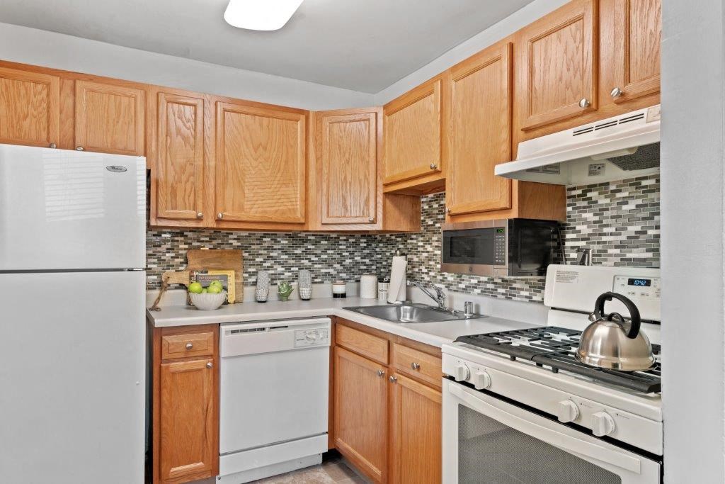 a kitchen with white appliances and wooden cabinets
