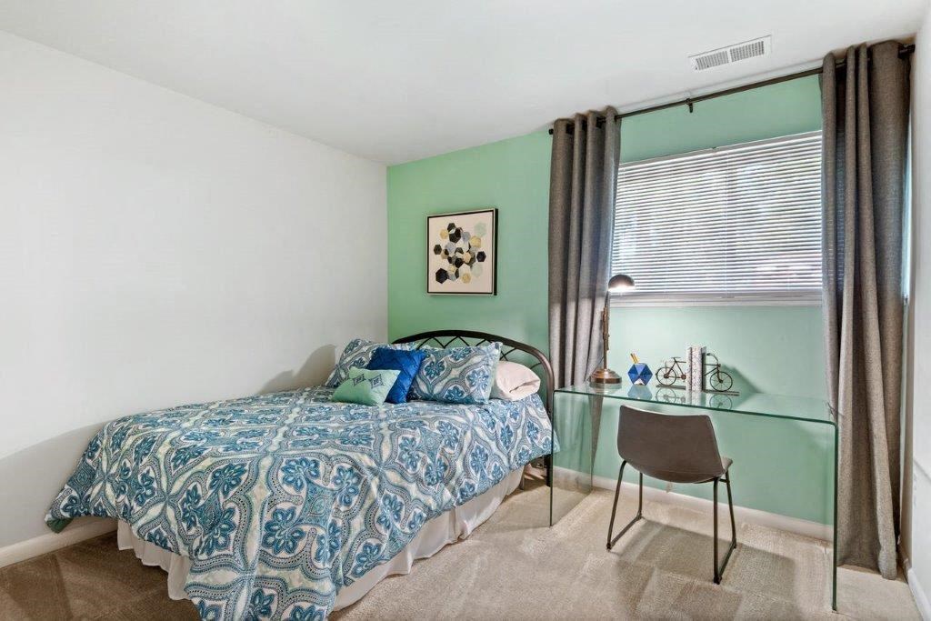 a bedroom with a bed and a desk with a chair