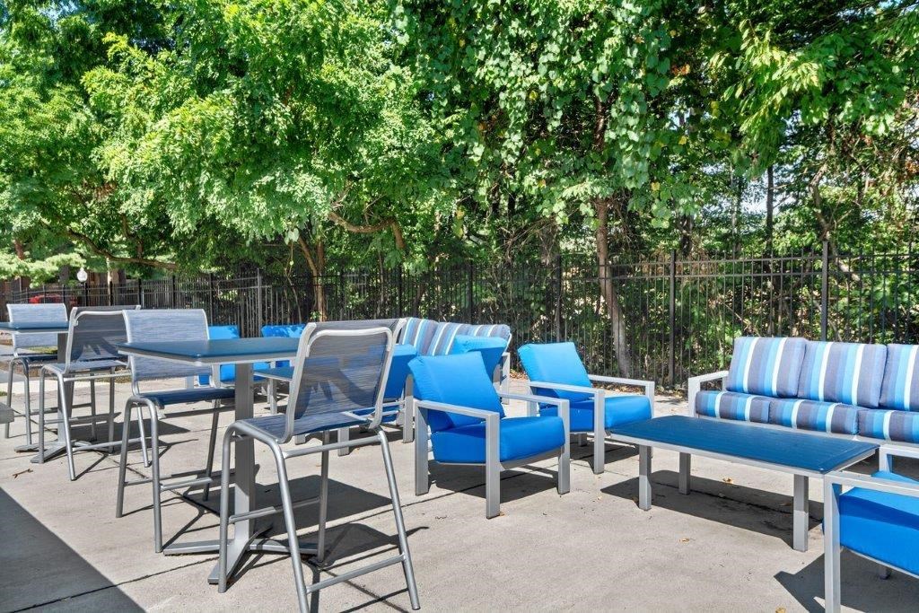 an outdoor lounge area with blue chairs and tables