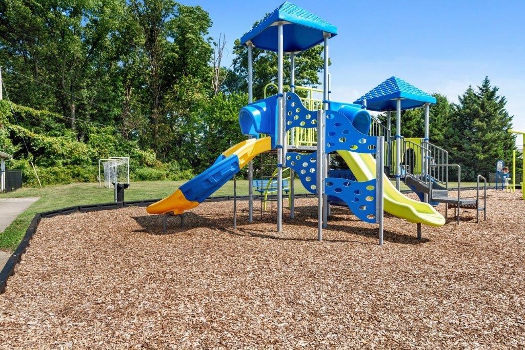 a playground with a blue and yellow swing set