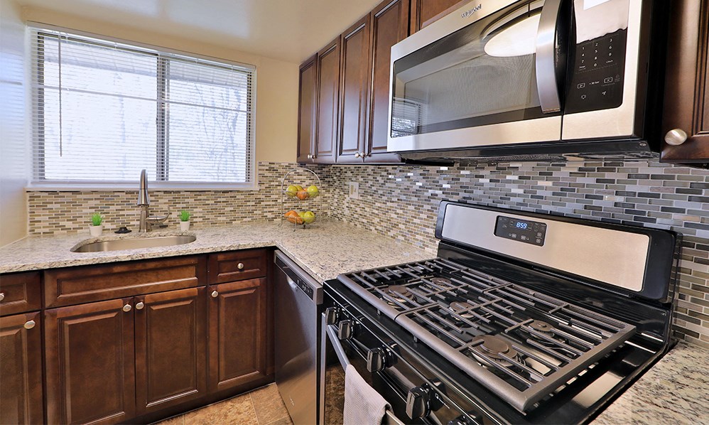 a kitchen with a stove and a sink and a microwave