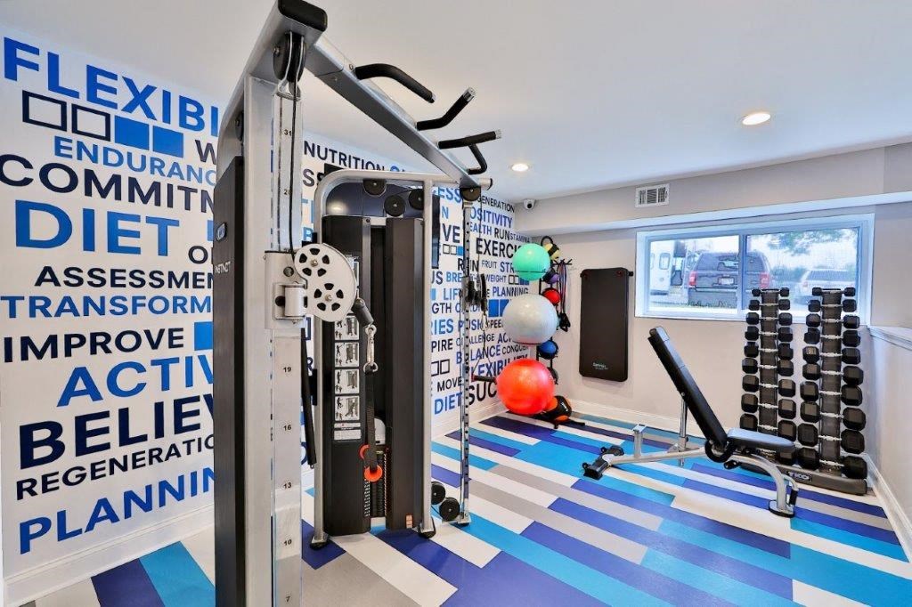 a gym with weights and other equipment in a room with a window