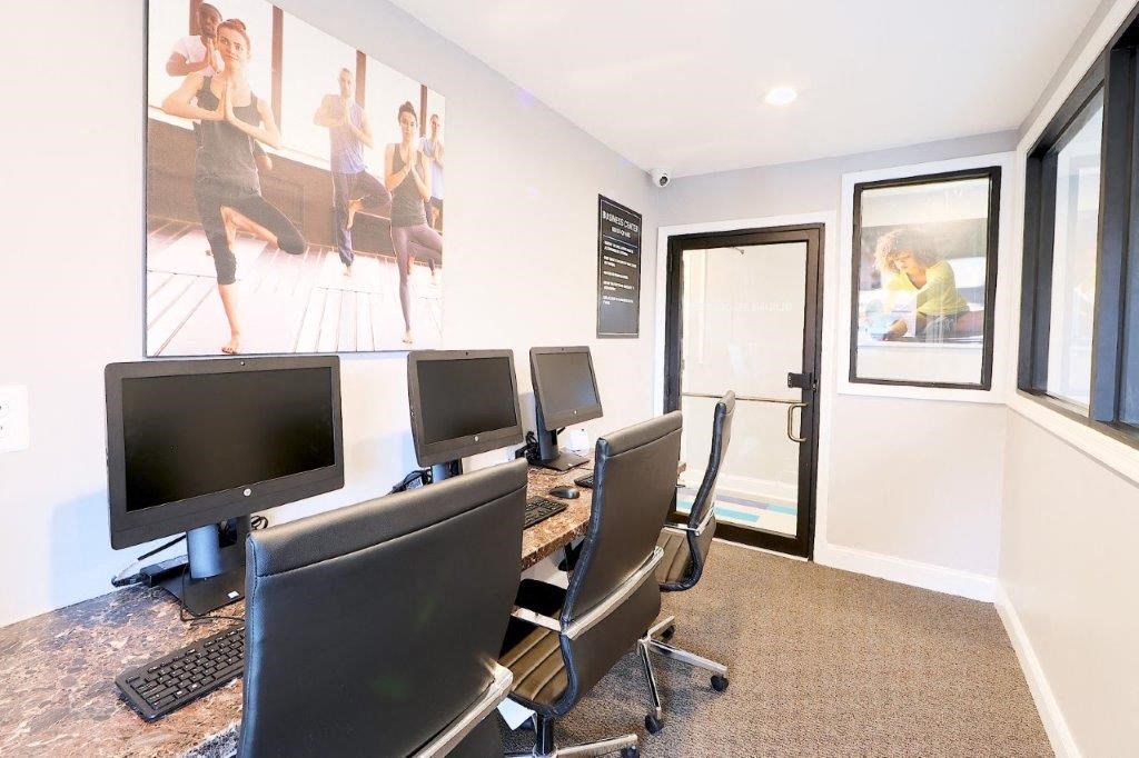 a conference room with computer monitors and chairs