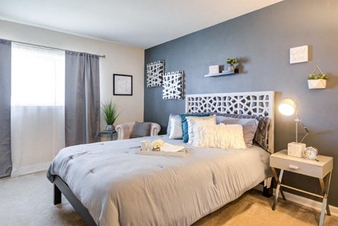 a bedroom with a bed and a blue accent wall