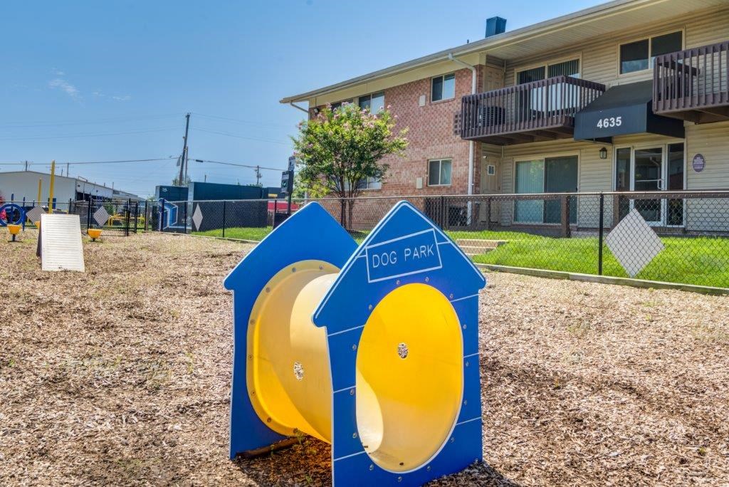 two blue and yellow urinals and a playground in front of a house