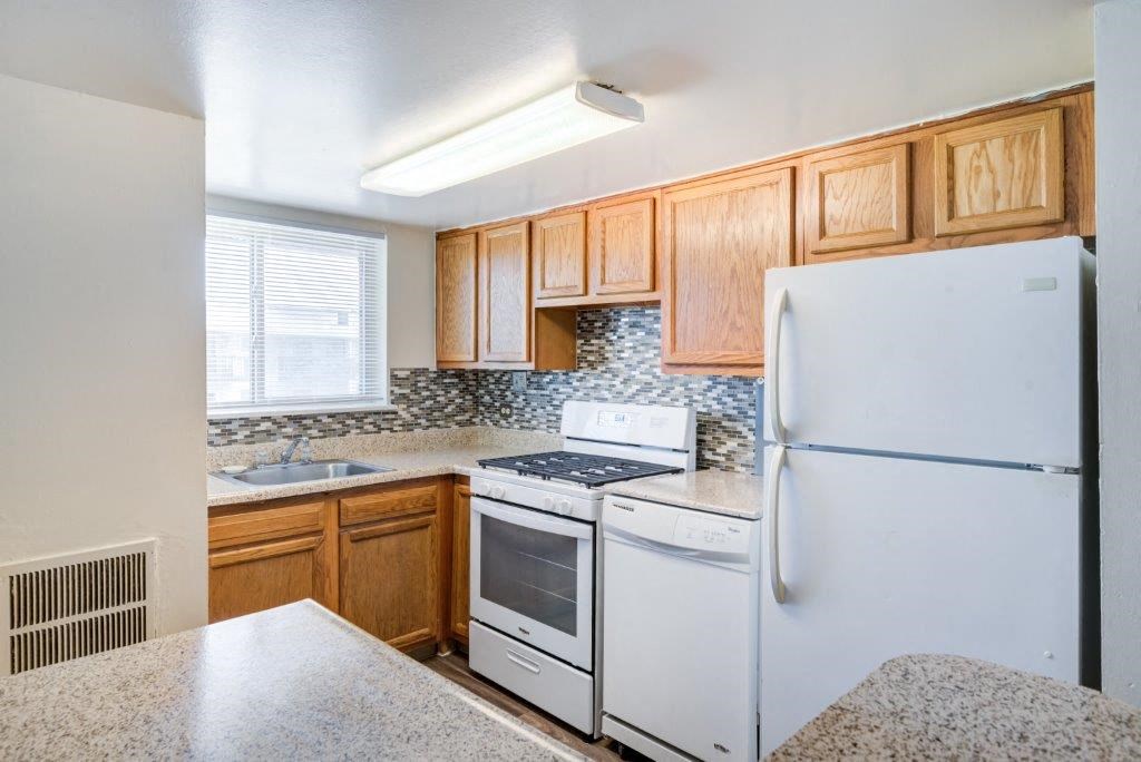 a kitchen with white appliances and wooden cabinets