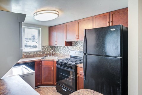 a kitchen with black appliances and wooden cabinets