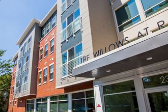 a large building with a sign that reads the willows apartments