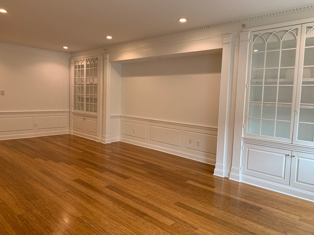 a dining room with a wood floor and white cabinets