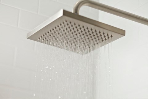 a shower with water dripping from it in a bathroom