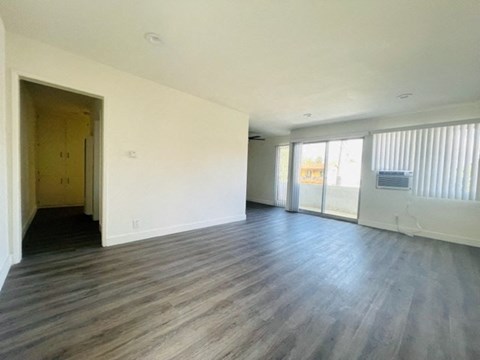 an empty living room with white walls and wood floors