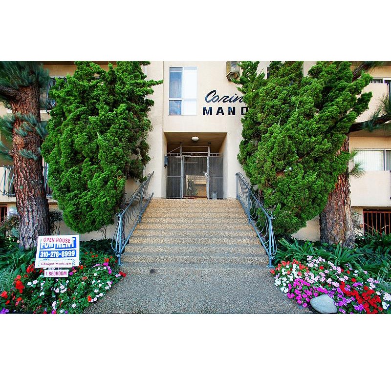 the front of a building with stairs and a sign