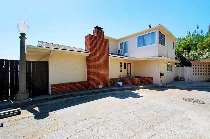 A house with a red brick chimney and a white garage door.
