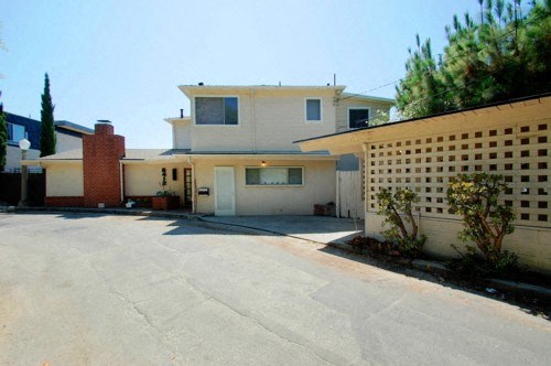 A house with a white garage door and a brown door.