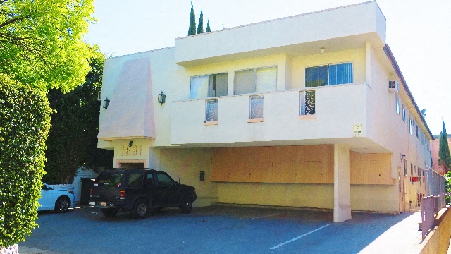an apartment building with a car parked in front of it