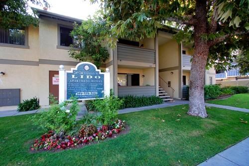 a building with a sign and a tree in front of it