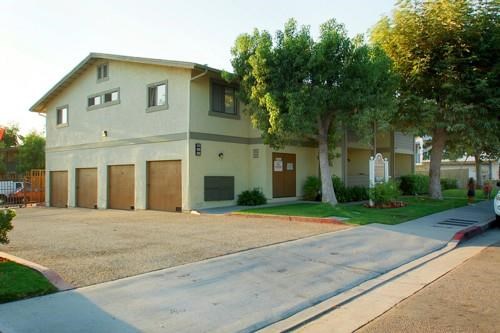 a white house with a driveway and some trees