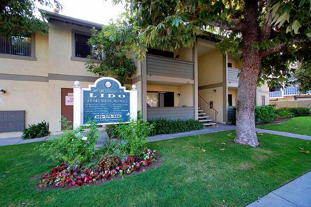 a building with a sign and a tree in front of it