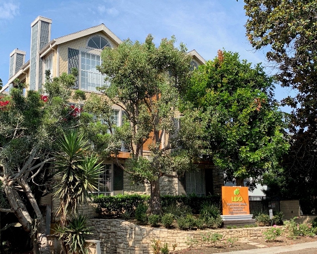 a house with trees and a sign in front of it