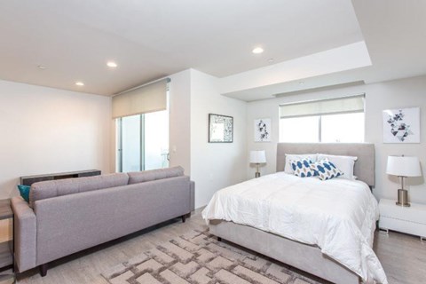 a white bedroom with a couch and a bed