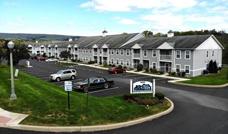 an aerial view of an apartment building with cars parked in a parking lot